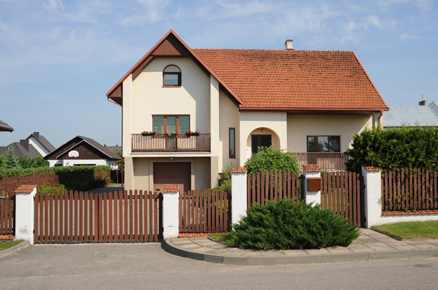 Деревянный забор из штакетника перед фасадом дома