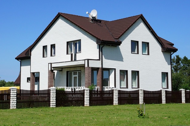 Деревянный забор из штакетника перед фасадом дома