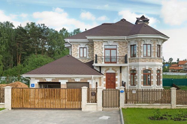 Деревянный забор из штакетника перед фасадом дома